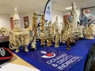 Photo présentant des statuettes d'ivoire avant leur destruction. Trois agent de l'OFB sont présents en fond.