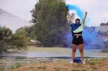 Photo de l'actrice du spectacle tenant à bout de bras des fumigènes bleus