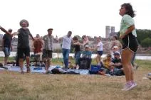 Photo du spectacle ENFIN. L'actrice saute sur place alors que le public s'organise en farandole