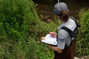 Une agente de l'OFB est en train de noter des données sur une feuille terrain