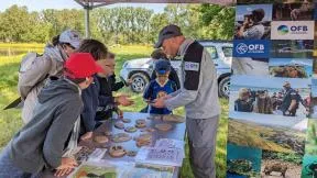 Photo montrant un agent de l'OFB en train d'expliquer à des enfants les différentes traces d'animaux