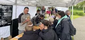 Photo d'un agent de l'OFB s'entretenant avec des enfants lors d'un salon sur la biodiversité
