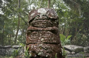 Photo d'un tiki, représentation humaine sculptée dans de la pierre
