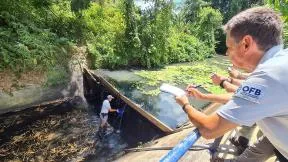 Photo de deux agents en rivière sont en train de réaliser des prélévements d'eau