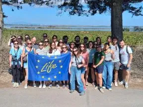 L'équipe du projet Life Biodiv'France, environ 20 personnes, pose groupe derrière le drapeau Life Europe.