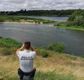 Policier de l'environnement en surveillance en bord de Loire avec jumelles
