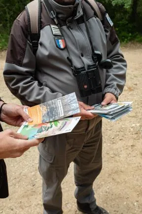 Distribution de flyer pour sensibiliser la population à la biodiversité, par un agent de l'ofb à un usager