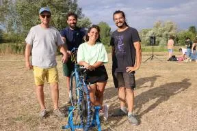 Photo de 4 membres de "En transition cie" posant autour du vélo générateur d'électricité présenté durant le spectacle "ENFIN"