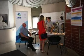 Photo du stand de l'OFB en présence d'une agent OFB et de deux visiteurs