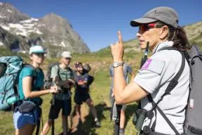 Une agente du Parc National des Écrins échange avec des randonneurs en montagne
