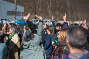 En extérieur, des personnes votent à main levée