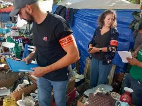 Un agent de l'OFB contrôlant des exposants en vérifiant un objet en ivoire