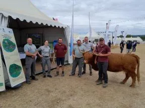 agents de l'OFB avec une vache Hightland devant le stand OFB