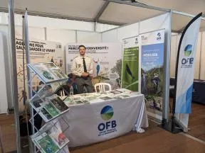 Un agent de l'OFB se tient sur un stand composé de kakémonos, porte brochures etc.