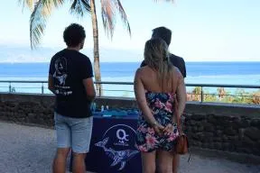 Photo de deux membres de l'association Oceania qui sensibilisent les visiteurs de Moorea à la problématique des collisions entre les bateaux et les baleines à bosses
