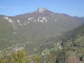 Photo du paysage montagneux avec une vallée forestiere et des habitations au premier plan